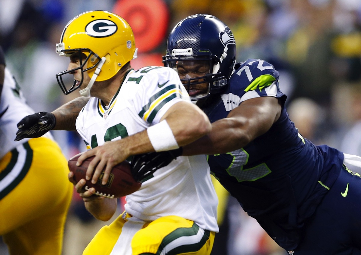Aaron Rodgers gets sacked by Michael Bennett, resulting in a safety. Photo by Joe Nicholson—USA TODAY Sports.